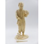 A SIGNED JAPANESE CARVED IVORY SECTIONAL FIGURE OF A STANDING GARDENER. H.19.5cms.