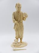 A SIGNED JAPANESE CARVED IVORY SECTIONAL FIGURE OF A STANDING GARDENER. H.19.5cms.