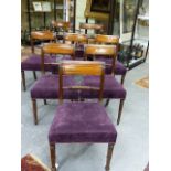 A SET OF EIGHT REGENCY STYLE MAHOGANY DINING CHAIRS WITH OVER STUFFED SEATS ON TURNED FORELEGS.