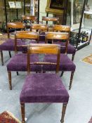 A SET OF EIGHT REGENCY STYLE MAHOGANY DINING CHAIRS WITH OVER STUFFED SEATS ON TURNED FORELEGS.