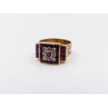 A PRECIOUS YELLOW METAL RUBY AND DIAMOND RING. EMERALD CUT RUBIES ARE INSET INTO A GEOMETRIC SETTING