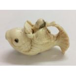 Carved Ivory Netsuke Man reading from scroll astride a carp, signed