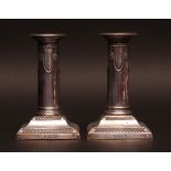 Pair of late Victorian dwarf candlesticks, the stems moulded with floral garlands on stepped