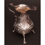 Early George III milk jug with cut card rim to a baluster body with leaf capped cast and applied