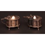 Pair of Edward VII silver mustard pots of shaped oval form, raised on four plain feet, Chester 1908,