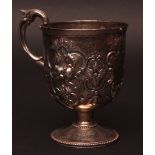 Victorian Christening mug of circular pedestal form with scroll capped handle, body heavily embossed