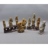 Two Chinese soapstone stands, each displaying three carved soapstone immortals together with two