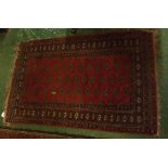 Small Bokhara type rug, central panel of lozenges within a multi-gull border, mainly red field,