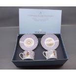 Boxed Wedgwood Millennium celebration cups and saucers, decorated in figural scenes with