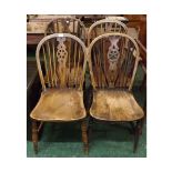 Set of four elm hard seated stick back wheel back kitchen chairs, on turned front legs and H-