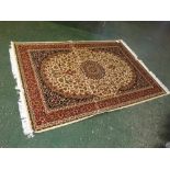 A Modern Keshan carpet with central cream and floral motif, blue and red borders, 90" x 62"