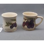Pair of Moorcroft plum patterned mugs with impressed mark to base, with chips to foot, 3 1/2" high