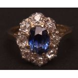 Precious metal diamond and sapphire cluster ring, the facetted central oval shaped sapphire (70mm