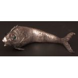White metal model of an articulated fish, of typical form with green cabochon set eyes, and with