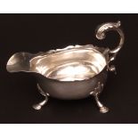 George III gravy boat of typical polished form with cut card rim and cast and applied leaf capped
