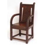 Unusual Arts & Crafts type carved oak armchair, the cresting rail and spreading arms ornately carved