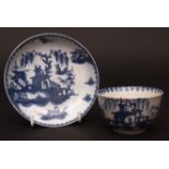 A Lowestoft tea bowl & a saucer c1760 painted in tones of dark blue with a house and Chinese river