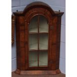 Walnut corner cupboard with domed top over glazed door enclosing green painted interior with