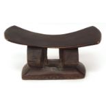 African carved hardwood tribal or folk art carved stool, curved seat over geometric support on a