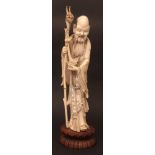 Chinese ivory carving of an immortal holding a peach, and a dragon headed staff, his robes