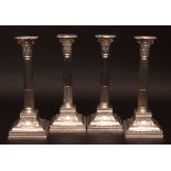 Four George V single candlesticks, each modelled in the form of a Corinthian column with