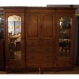 Late 19th/early 20th century large light oak compendium wardrobe, with breakfront dentil cornice,