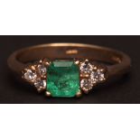 Modern 18ct gold emerald and diamond ring, the square cut emerald (4mm x 4mm app) between diamond