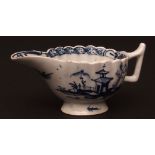 A Lowestoft cream boat c1765 of fluted form on a low pedestal foot painted in dark blue with Chinese