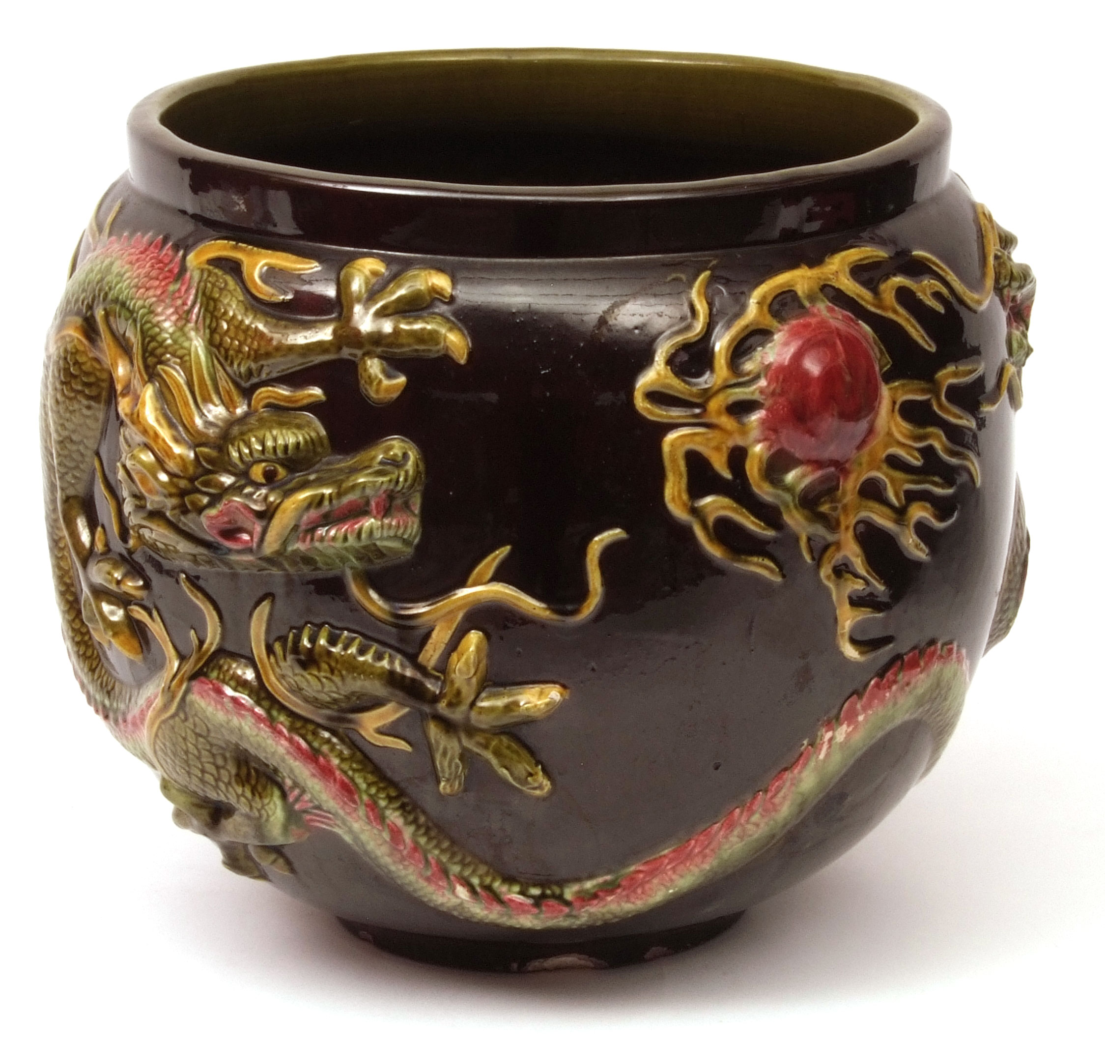 Large Bretby Pottery jardiniere, elaborately moulded with coiled dragons on a dark treacle ground