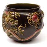 Large Bretby Pottery jardiniere, elaborately moulded with coiled dragons on a dark treacle ground