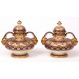 Pair of late 19th century Derby two-handled covered small urns of squat baluster form, painted in