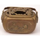 Chinese cast brass hand warmer of typical form with loop handle, the lid pierced with a dragon,