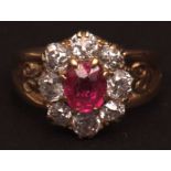 Mid-grade yellow metal ruby and diamond cluster ring, the centre oval cut ruby surrounded by eight