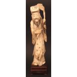 Chinese ivory carving of an immortal holding a cloud topped staff, a sword slung across his back,