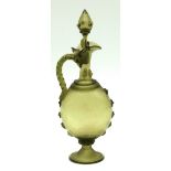 Pale green glass claret jug with conical stopper, wrythen handle and wrythen ovoid body