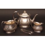 George V three piece tea set comprising tea pot, sugar basin and milk jug, each of half fluted