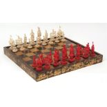 Chinese finely carved red stained and white ivory chess set contained in original black and gold