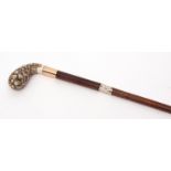 Ornate walking cane, the carved ivory handle decorated with dog heads with naturalistic red eyes