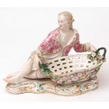Dresden pot-pourri holder modelled as a young reclining dandy beside a basket, encrusted in