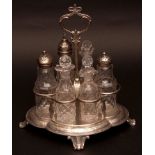 Victorian six bottle cruet stand, the lobed oval base raised on four cast and applied feet to a