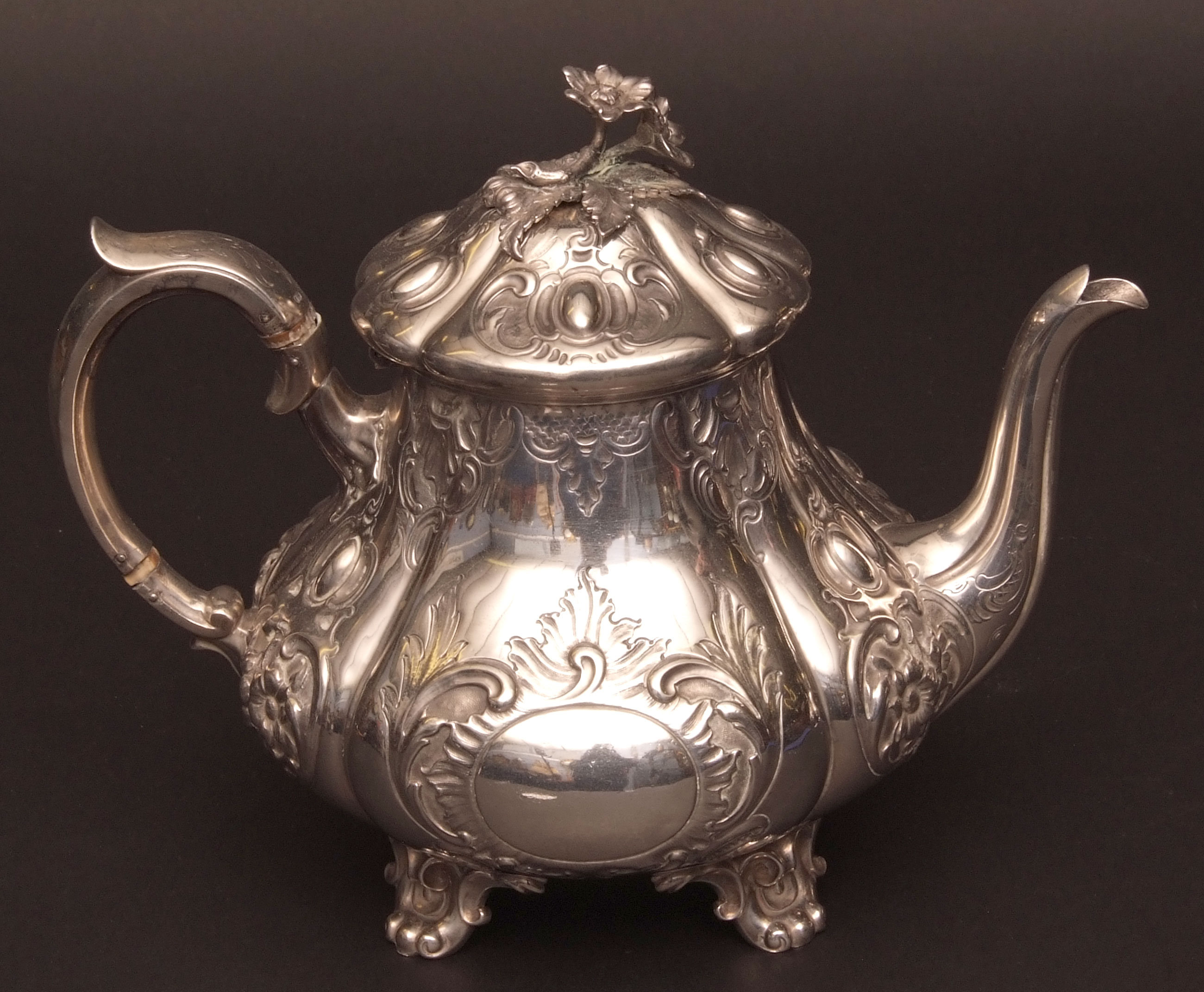 Victorian teapot of lobed baluster form with hinged and domed cover with cast and applied floral