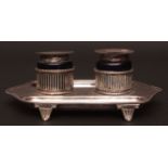 George V inkstand, of shaped form with applied beaded rim and raised on four cast and applied