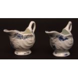 A pair of Lowestoft dolphin ewer shape cream boats c1775 shell shaped on a low pedestal foot with