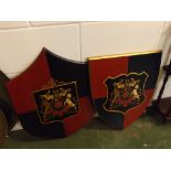 Two decorative modern painted shields with central armorial crest, each approx 18ins x 21ins