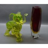 Unsigned studio glass model of an elephant, with red eyes and white glass tusk with raised trunk,