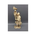 Japanese ivory okimono of fish-seller holding a basket with bird of prey perched on his hand and