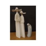 Lladro figure of a kneeling cloaked woman, together with a further Lladro figure of two nuns,