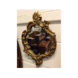 Italian style 20th century rococo shaped mirror with gilded and carved decoration, 18ins x 12ins