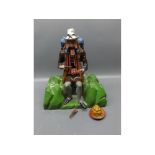 Carved and painted folk art wooden articulated model of a traveller seated eating a pie, with