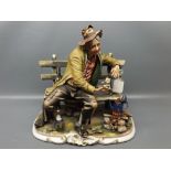 Large Capodimonte china mode of a tramp seated feeding a cat on a bench, 11 1/2 ins wide, 13 ins